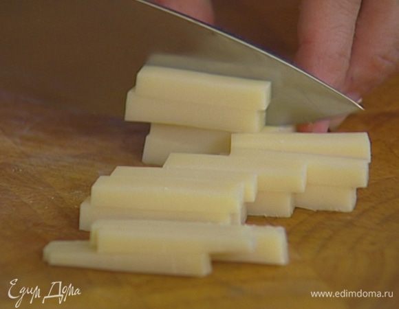 Сыр нарезать кусочками, выложить на салатные листья.