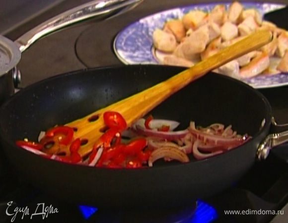 Перец чили порезать кольцами, отправить к луку и немного обжарить.