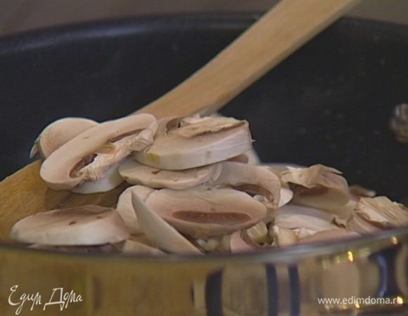 Шампиньоны нарезать пластинками, добавить к луку с чесноком, посолить, поперчить, перемешать и оставить тушиться. 