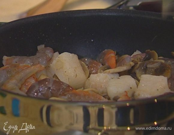 Рыбное филе нарезать на небольшие кусочки, выложить в сковороду к грибам, добавить размороженные креветки, посолить, поперчить, перемешать. Влить 2 ст. ложки вина, посыпать приправой к рыбе. 