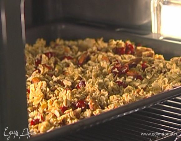 Противень с гранолой поместить в разогретую духовку, сразу же уменьшить температуру до 150°С и оставить на 10 минут.  