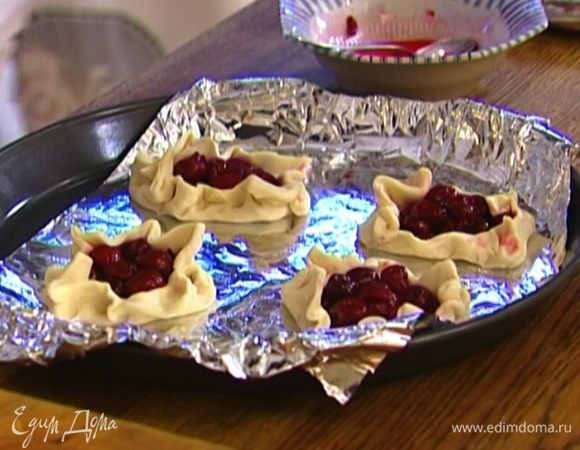 Сверху на каждый квадрат выложить ягоды, немного защипнуть края.