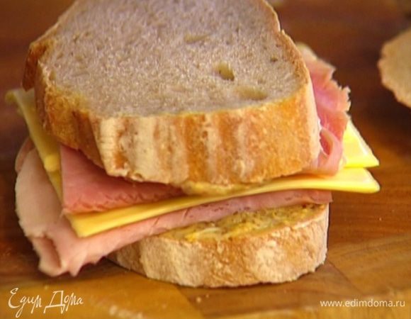 На один кусок хлеба положить ветчину, затем пару пластинок сыра, сверху опять ветчину, накрыть вторым куском хлеба. Излишки ветчины и сыра по бокам срезать ножом.