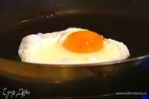 В другой сковороде разогреть немного оливкового масла, разбить туда оставшееся яйцо так, чтобы желток остался целым, а белок получился красивой круглой формы, и пожарить, не переворачивая.