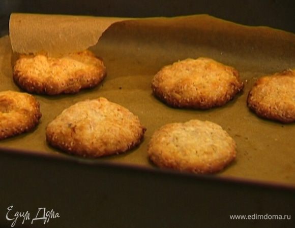 Противень застелить бумагой для выпечки, смазать ее оливковым маслом, выложить шарики из теста и слегка придавить их.  Выпекать печенье в разогретой духовке 10–12 минут.