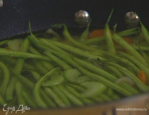 Добавить фасоль, перемешать овощи, залить горячим, подсоленным овощным бульоном, довести до кипения, накрыть крышкой и варить на небольшом огне 15 минут.