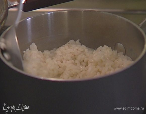 В отваренный рис влить рисовый уксус и 1/2 ч. ложки кунжутного масла, перемешать.