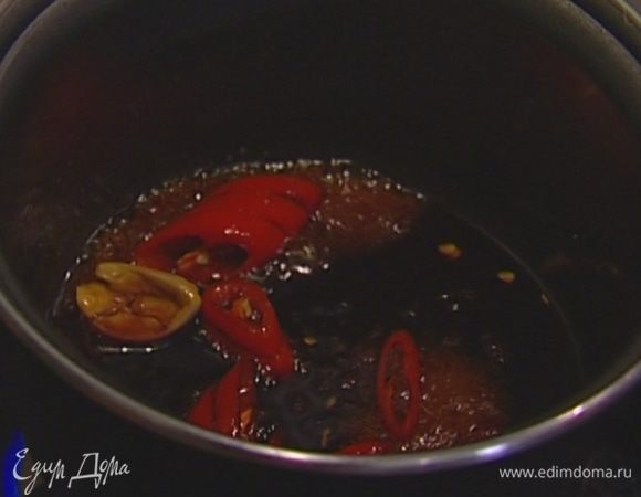 В небольшой сотейник влить соевый соус, 1 ст. ложку кунжутного масла, добавить сахар, чеснок и чили. Поставить сотейник на огонь и уваривать кунжутно-соевый соус, пока он не станет карамельным, затем процедить через сито. 