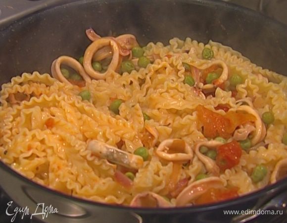 Макароны отварить в подсоленной воде согласно инструкции на упаковке, затем воду слить и сохранить, пасту выложить к кальмарам, все перемешать. Если получится суховато, добавить немного воды, в которой макароны варились. 