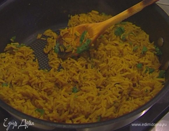 Кинзу мелко порубить, присыпать рис, перемешать и посыпать орехами.