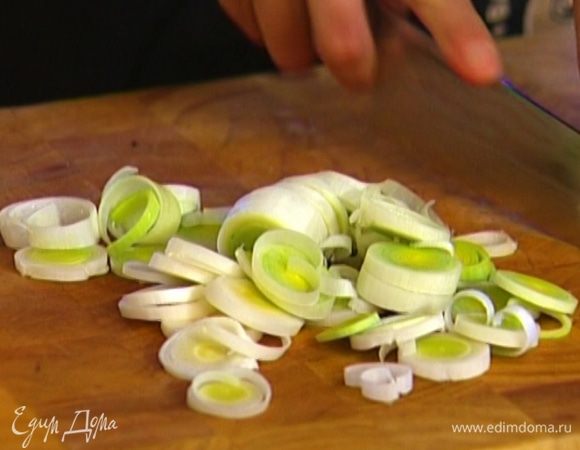 Светлую часть лука-порея нарезать тонкими кольцами.