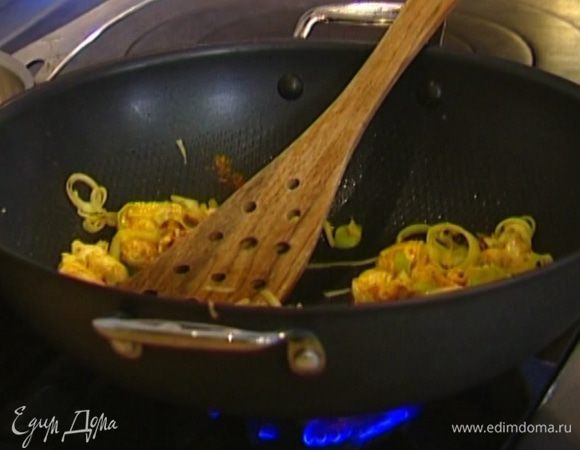 Разогреть в воке оливковое масло и обжаривать лук и чеснок 1 минуту, затем добавить куриное мясо и карри. Перемешать. 