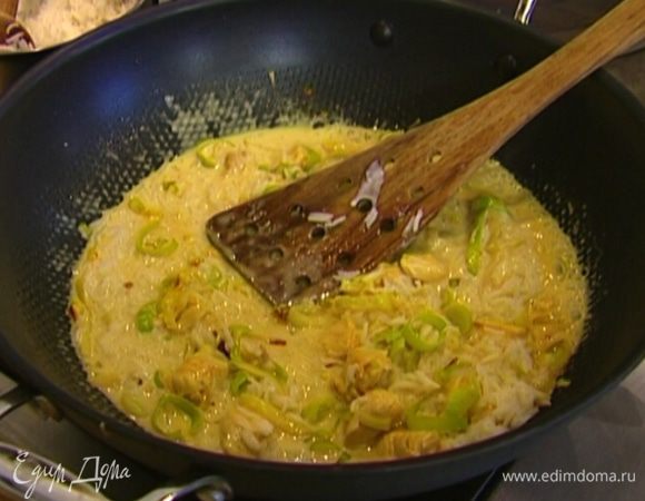 Добавить кокосовое молоко и 2 ст. ложки готового риса, перемешать и потомить 3–4 минуты. 