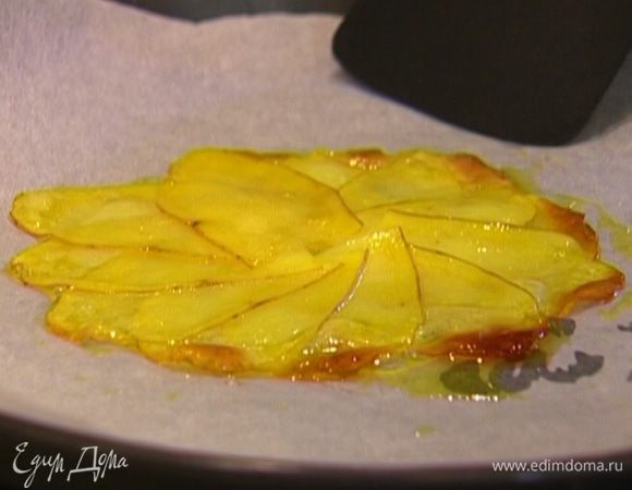 Противень застелить бумагой для выпечки, слегка смазать ее оливковым маслом, выложить картофельные лепестки в форме цветка и запекать в разогретой духовке около 7 минут, затем перевернуть и продолжать запекать, пока лепестки не зазолотятся.