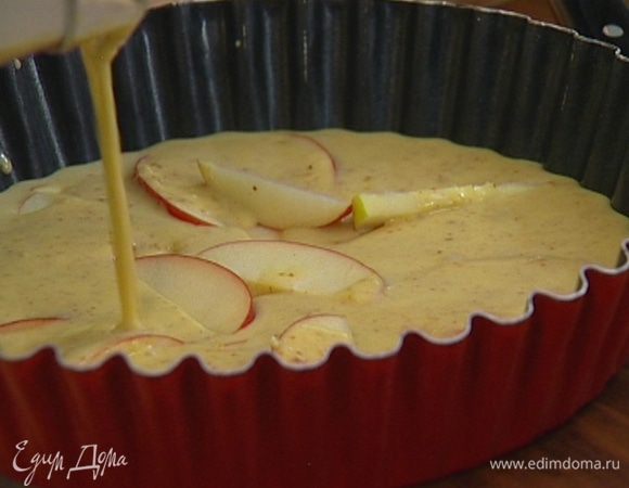 В тефлоновую форму для выпечки влить половину теста, выложить часть яблок, затем влить вторую половину теста и выложить оставшиеся яблоки.  