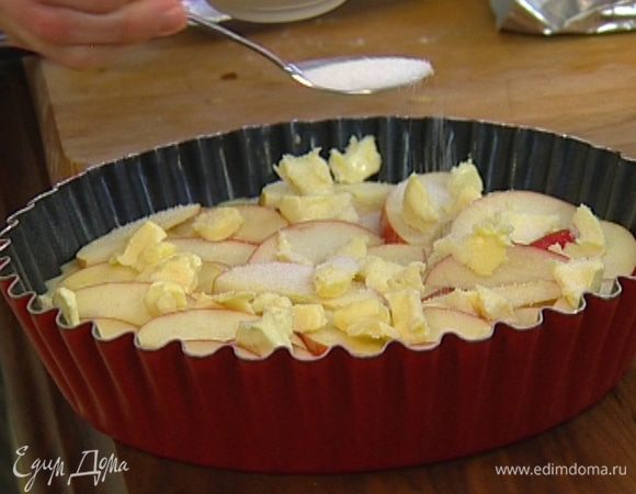 Порезать небольшими кубиками 60 г предварительно охлажденного сливочного масла и разложить на яблоки, сверху посыпать оставшимся сахаром.  