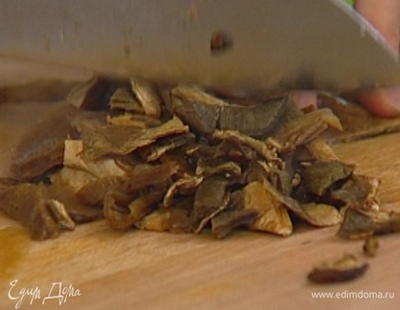 Воду, в которой замачивались сухие грибы, слить и сохранить, а сами грибы порубить ножом.