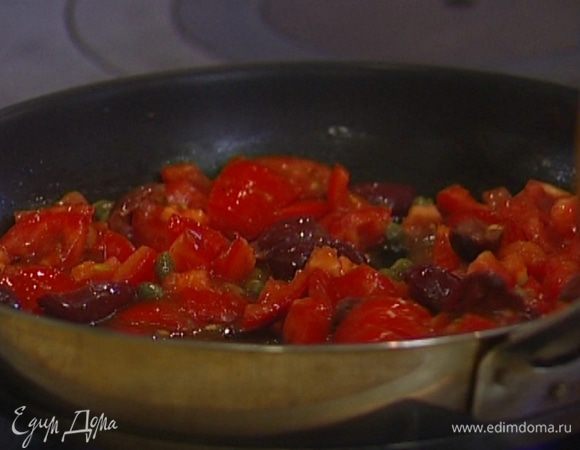 Разогреть в сковороде немного оливкового масла, отправить туда помидоры, оливки и каперсы, добавить томатный соус, все посолить, немного прогреть и снять с огня. 