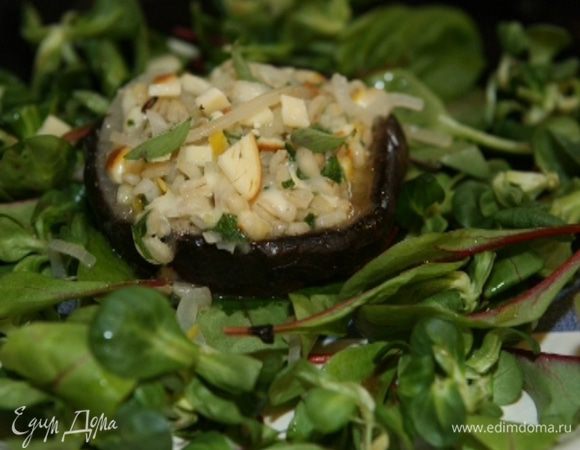 Снова накрыть грибы фольгой, вернуть в духовку и запекать еще 3−5 минут.  Выложить на блюдо листья салата, сбрызнуть оставшимся оливковым маслом, сверху разложить грибы и полить все грибным соком из противня. 