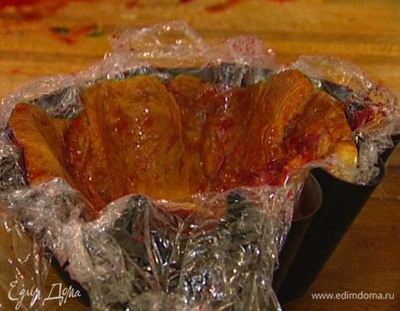 Высокую форму для выпечки выстелить несколькими слоями пищевой пленки. Круассаны разрезать вдоль на 2−3 части, половину из них смазать с одной стороны сиропом (удобно делать это кулинарной кисточкой) и уложить, прижимая ко дну и стенкам формы смазанной частью. 