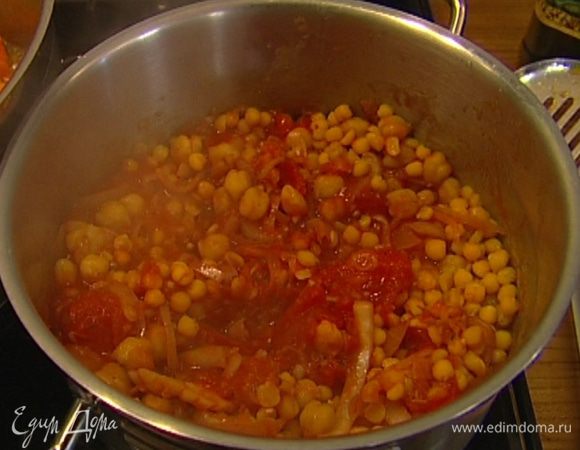 Добавить помидоры с пряностями к нуту, туда же с помощью шумовки выложить отваренный горох и подержать все на огне еще 2−3 минуты. 