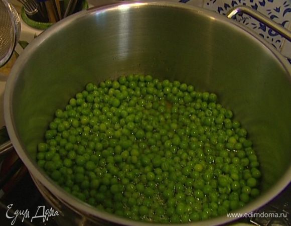 Зеленый горошек разморозить. Влить в кастрюлю немного воды и 1 ст. ложку оливкового масла, добавить горошек и отваривать его в течение 3 минут, затем воду слить. 