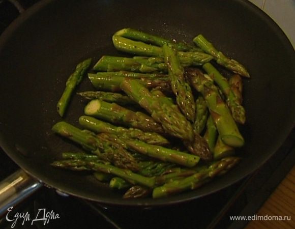Переложить грибы в другую посуду, в сковороде разогреть еще 1 ст. ложку оливкового масла и обжарить верхушки спаржи, посолив и поперчив их.