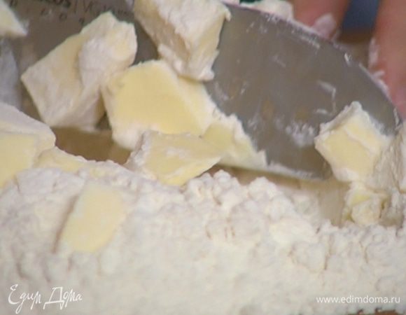 Приготовить тесто: оба вида муки порубить ножом вместе с предварительно охлажденным сливочным маслом, так чтобы получилась мелкая крошка.