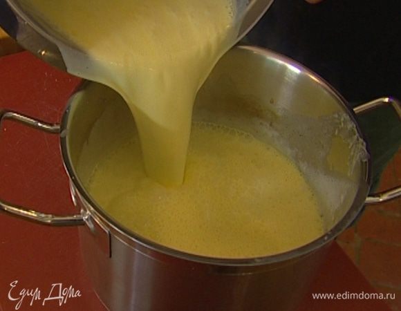 Непрерывно помешивая, тонкой струйкой влить в желтки горячие сливки с молоком. 