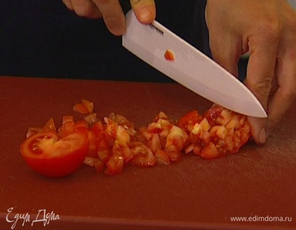 Помидоры нарезать мелкими кубиками, соединить с половиной салатных листьев, посолить и поперчить.