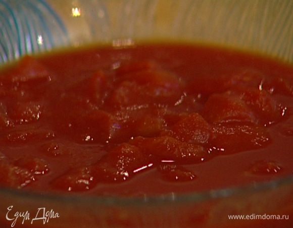 Приготовить соус: разогреть в сковороде 2−3 ст. ложки оливкового масла, обжарить лук и чеснок, затем добавить перец чили, помидоры в собственном соку, посолить, поперчить и тушить на медленном огне несколько минут, чтобы соус загустел. 