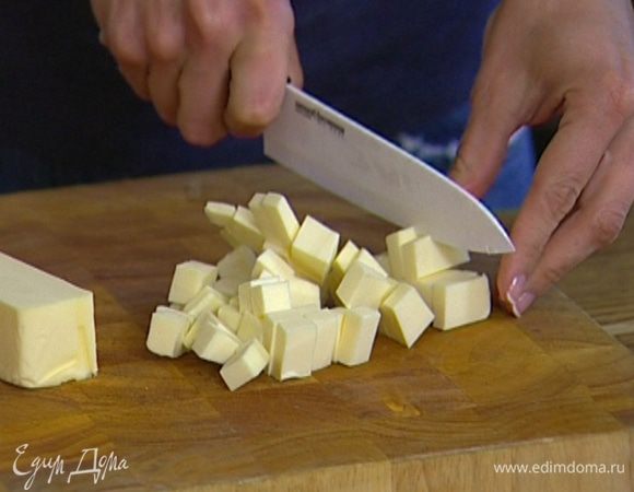 Предварительно охлажденное сливочное масло порубить кубиками.