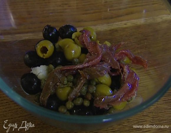Приготовить тапенад: оливки соединить с каперсами, чесноком и анчоусами, добавить 1 ст. ложку оливкового масла, щепотку свежемолотого черного перца и взбить все до однородного состояния.