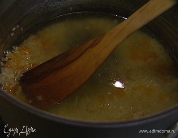 Всыпать рис, залить все овощным бульоном, довести до кипения, уменьшить огонь, накрыть крышкой и варить рис до готовности.