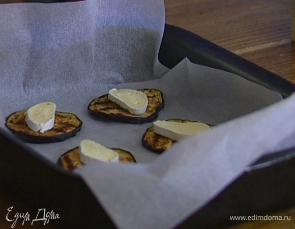 Выстелить противень бумагой для выпечки, уложить на нее половину обжаренных баклажанов.