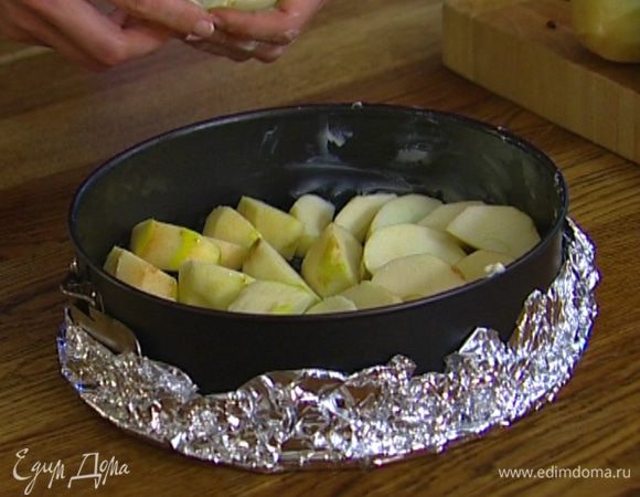 Смазать сливочным маслом разъемную форму (при необходимости выстелить фольгой, чтобы тесто не вытекало) и уложить в нее дольки яблок как можно плотнее друг к другу.  