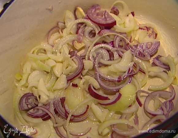 Разогреть в тяжелой кастрюле 3−4 ст. ложки оливкового масла, слегка обжарить лук и чеснок.