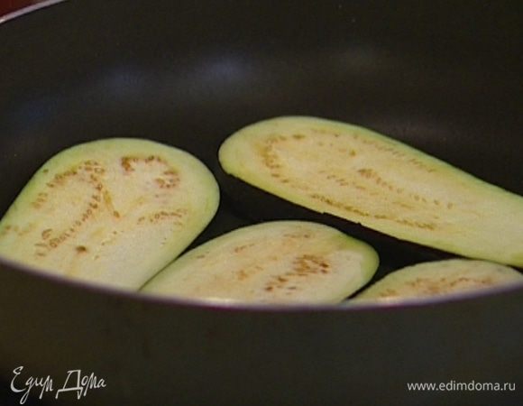Баклажаны нарезать длинными пластинками и обжарить в сковороде до полной готовности, не жалея масла, затем выложить на бумажное полотенце, чтобы лишнее масло ушло.