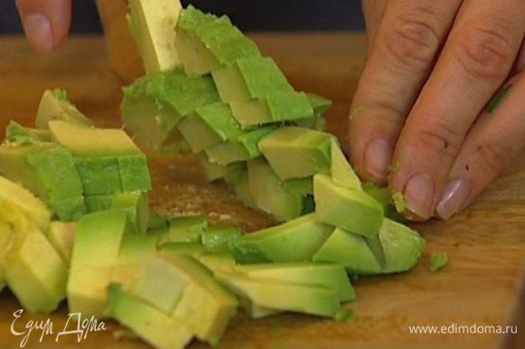 Оставшуюся половинку авокадо нарезать маленькими кубиками.