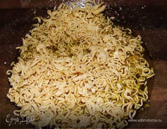 Крошим нашу лапшу в дрессинг и пока мы будем делать салат она слегка станет мягче, как раз, что нам нужно. Перемешиваем.