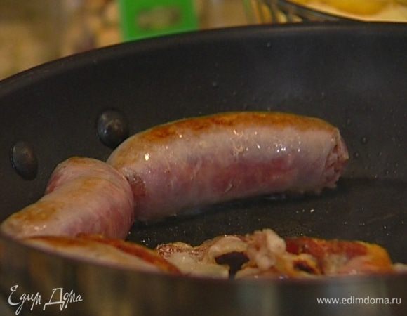 Бекон и колбаски поджарить в сковороде, затем бекон переложить в другую посуду.