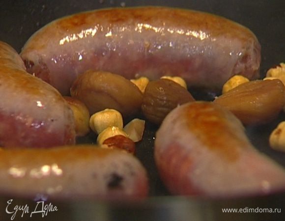 В сковороду к колбаскам выложить орехи и каштаны и слегка прогреть, чтобы они пропитались ароматами жареного.