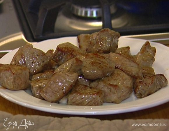 Разогреть в тяжелой сковороде оливковое масло и обжарить кусочки мяса со всех сторон до легкой золотистой корочки, затем выложить на тарелку.