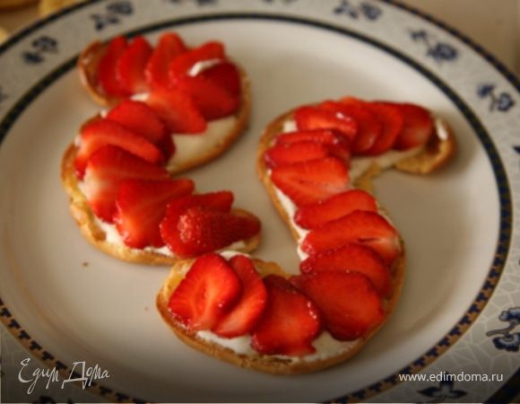 Готовые змейки остудить и разрезать вдоль на две части.Сливки взбить с сахаром в пышную пену.Разрезать стручок ванили и извлечь из него семена.Аккуратно добать их в сливки и перемешать.Клубнику нарезать пластинками.В каждую половинку "змеек" выложить взбитые сливки,а сверху уложить клубнику.