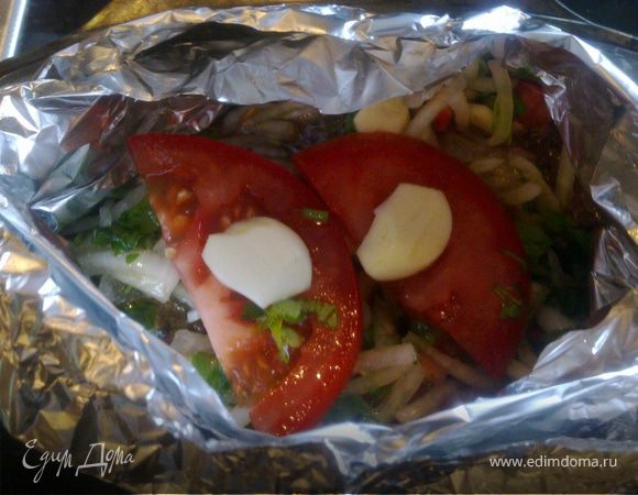 Делаем карман из фольги,сверху выкладываем пару кусочков помидора,нарезаный пластинами чеснок.