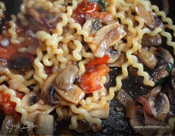 На сильном огне, на оливковом масле, обжарьте по-очереди добавляя лук, чеснок, грибы и помидоры. Посолите, поперчите. Порвите базилик руками. Как только зелень начнет вянуть добавьте макароны и немного водички в которой они варились. Накройте крышкой и протушите минуты 3-5. 
