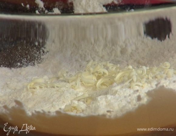 Натереть на крупной терке 125 г предварительно охлажденного сливочного масла, просеять в него муку, перемешать.
