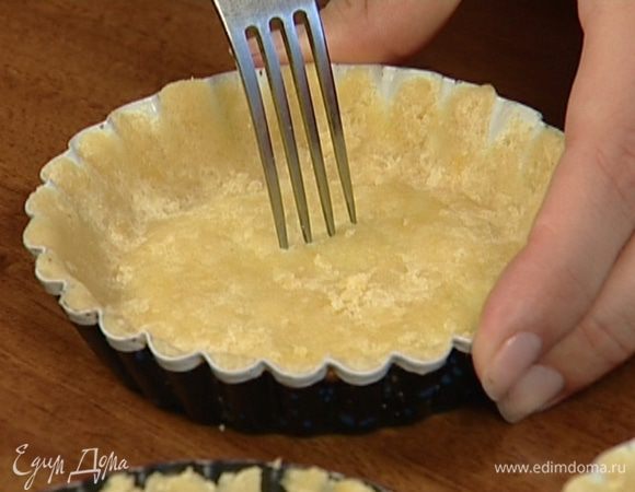 Смазать небольшие формочки оставшимся сливочным маслом, выложить в них тесто и, прижимая пальцами, распределить равномерно по дну и стенкам. Проткнуть тесто в нескольких местах вилкой и выпекать в разогретой духовке 10–15 минут.