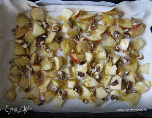 Выложить на корж яблоки, орехи и полить медом (если он уже засахарился его можно растопить).