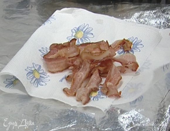 Бекон нарезать длинными полосками, обжарить на сухой сковороде до золотистого цвета и выложить на бумажное полотенце.